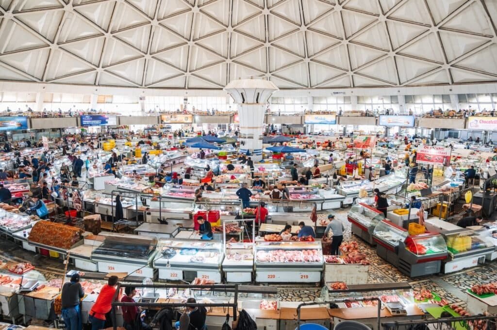 Tradiční orientální asijské uzbecké jídlo na bazaaru Chorsu s prodejci a kupujícími. Taškent, Uzbekistán.